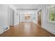 Open living room with gleaming hardwood floors, white walls, and beamed ceiling at 2140 S Washington St, Denver, CO 80210