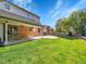 Lush backyard features a well-maintained lawn, covered patio, and mature trees at 7405 S Jackson Ct, Centennial, CO 80122