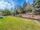 Lush backyard with tiered landscaping, mature trees, and green lawn at 7405 S Jackson Ct, Centennial, CO 80122
