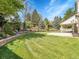 Spacious backyard featuring lush lawn, mature trees and a quaint retaining wall at 7405 S Jackson Ct, Centennial, CO 80122