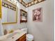 Charming half-bathroom with decorative wallpaper, a framed mirror, and vintage-style fixtures at 7405 S Jackson Ct, Centennial, CO 80122
