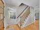 Welcoming foyer with hardwood floors, a staircase, and views into the living room at 7405 S Jackson Ct, Centennial, CO 80122