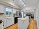 Open kitchen featuring white cabinetry, an island, stainless steel appliances, and wood floors at 7405 S Jackson Ct, Centennial, CO 80122