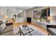 Open living room featuring hardwood floors, a bay window, and seamless flow to the kitchen and dining areas at 7405 S Jackson Ct, Centennial, CO 80122
