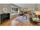 Cozy living room with a brick fireplace, bay window, hardwood floors, and comfortable seating at 7405 S Jackson Ct, Centennial, CO 80122