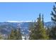 Scenic mountain view with snow-capped peaks, framed by lush green trees against a clear blue sky at 2035 Highlands Dr, Breckenridge, CO 80424