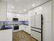 Modern kitchen with white cabinets, stainless steel appliances, and black countertops at 3184 S Heather Gardens Way # 406, Aurora, CO 80014