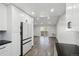 Bright kitchen featuring white cabinetry, modern appliances, and hardwood flooring with an open floor plan at 3184 S Heather Gardens Way # 406, Aurora, CO 80014