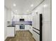 Modern kitchen with bright white cabinets, stainless steel appliances, and black countertops at 3184 S Heather Gardens Way # 406, Aurora, CO 80014