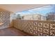 A covered patio with decorative block railing and wood-look tile flooring overlooks a neighboring building at 3184 S Heather Gardens Way # 406, Aurora, CO 80014