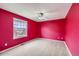 This is a bright red bedroom with neutral carpet and a large window at 2856 Penstemon Way, Castle Rock, CO 80109
