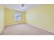 Sunny yellow bedroom with a ceiling fan, window, and neutral carpet at 2856 Penstemon Way, Castle Rock, CO 80109