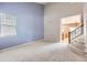 Bright, carpeted living room with high ceilings and staircase at 2856 Penstemon Way, Castle Rock, CO 80109