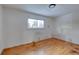 Simple bedroom with hardwood floors and a window, ready for personalization at 13643 E Exposition Ave, Aurora, CO 80012