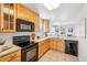 Well-equipped kitchen with wood cabinets and black appliances at 7616 S Sicily Way, Aurora, CO 80016