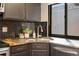 Modern kitchen close-up highlighting granite countertops, stainless steel faucet, dark cabinets, and decorative backsplash at 9400 E Iliff Ave # 37, Denver, CO 80231