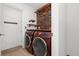 Functional laundry room with wooden shelves and modern washer and dryer units at 9400 E Iliff Ave # 37, Denver, CO 80231