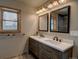 Bathroom featuring a double sink vanity with granite countertop, two mirrors and modern fixtures at 45 Oak Way, Evergreen, CO 80439