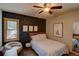 Bedroom with statement wall, upholstered bed, ceiling fan and sitting area with window at 45 Oak Way, Evergreen, CO 80439