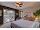 Cozy bedroom with a private balcony showcasing scenic views, complemented by a ceiling fan and ample natural light at 45 Oak Way, Evergreen, CO 80439
