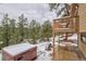 Relaxing deck area with hot tub and views of the surrounding woods at 45 Oak Way, Evergreen, CO 80439