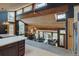 Open-concept living room boasting a beamed wood ceiling and cozy stone fireplace, seamlessly blending rustic charm with modern design at 45 Oak Way, Evergreen, CO 80439