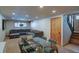 Open-concept living room with a sectional sofa, glass-top table, and hardwood floors at 45 Oak Way, Evergreen, CO 80439