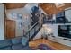 A modern living room with a staircase and stylish decor accents, including a wooden ceiling and creative lighting at 45 Oak Way, Evergreen, CO 80439
