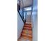 Wooden staircase with metal railings, leading to a bright doorway and skylight at 45 Oak Way, Evergreen, CO 80439