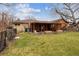 Large, well-maintained backyard with a patio area, mature trees, and ample space for outdoor enjoyment at 615 Estes St, Lakewood, CO 80215