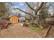 Spacious backyard with storage sheds, mature tree, and wooden swing set offers plenty of outdoor opportunities at 615 Estes St, Lakewood, CO 80215