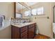 Bathroom with wooden cabinets, granite counters and a large mirror at 615 Estes St, Lakewood, CO 80215