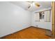 Clean bedroom with hardwood floors, ceiling fan and one window with curtains at 615 Estes St, Lakewood, CO 80215