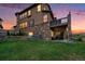 Beautiful two-story home with a stone exterior and a large backyard featuring a well-maintained lawn at 10705 Pinewalk Way, Highlands Ranch, CO 80130