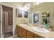 Well-lit bathroom with double sinks, decorative mirrors, and a bathtub/shower combo at 10705 Pinewalk Way, Highlands Ranch, CO 80130
