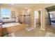 Bright bathroom boasts a luxurious soaking tub, a glass shower, and stylish neutral tile throughout at 10705 Pinewalk Way, Highlands Ranch, CO 80130