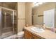 Well-lit bathroom featuring a glass-enclosed shower, vanity with a sink, and neutral-toned walls at 10705 Pinewalk Way, Highlands Ranch, CO 80130