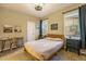 Inviting bedroom features a comfortable bed, a quaint desk, and natural light from the window at 10705 Pinewalk Way, Highlands Ranch, CO 80130