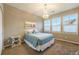 Comfortable bedroom boasts neutral colors, a cozy bed, and a lovely chandelier for a serene retreat at 10705 Pinewalk Way, Highlands Ranch, CO 80130