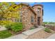 Beautiful exterior shot of a stone house with manicured landscaping and a walkway to the front door at 10705 Pinewalk Way, Highlands Ranch, CO 80130