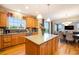Well-appointed kitchen with wood cabinets, a central island, and a seamless connection to the dining area at 10705 Pinewalk Way, Highlands Ranch, CO 80130