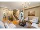 Inviting living room featuring a staircase, chandelier and open access to the dining area at 10705 Pinewalk Way, Highlands Ranch, CO 80130