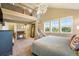 Bright main bedroom with a chandelier, staircase, and a view of the neighborhood through large windows at 10705 Pinewalk Way, Highlands Ranch, CO 80130