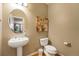 Stylish powder room with a pedestal sink, round mirror, decorative artwork, and wood look floors at 10705 Pinewalk Way, Highlands Ranch, CO 80130