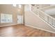 Inviting living area with lots of light, staircase, hardwood floors and neutral wall color at 9753 Gatesbury Cir, Highlands Ranch, CO 80126