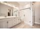 This primary bathroom offers a double vanity, a glass-enclosed shower, and stone tile flooring at 1807 Grayside Cir, Castle Rock, CO 80109