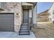 Close up view of the front door of the home, featuring stone veneer and a dark gray color palette at 1807 Grayside Cir, Castle Rock, CO 80109