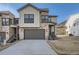 Inviting home featuring a 2-car garage, stone and siding exterior, and professional landscaping at 1807 Grayside Cir, Castle Rock, CO 80109