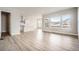 Open-concept living room with wood flooring, large windows, and an open flow to the kitchen at 1807 Grayside Cir, Castle Rock, CO 80109