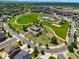 Aerial view of the community park including a pool, playing fields, a clubhouse, and green space at 17548 Bluetrail Ave, Parker, CO 80134